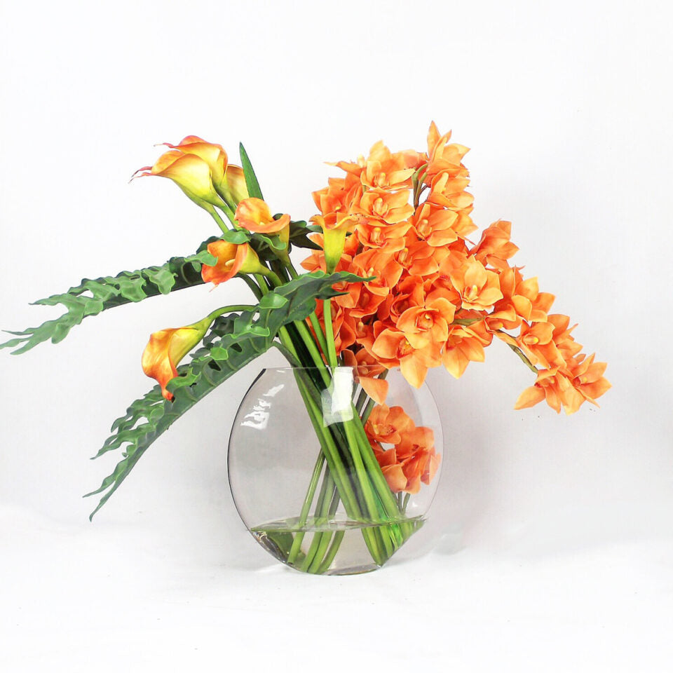 Cymbidiums naranjas y callas de mango en el jarrón Moon